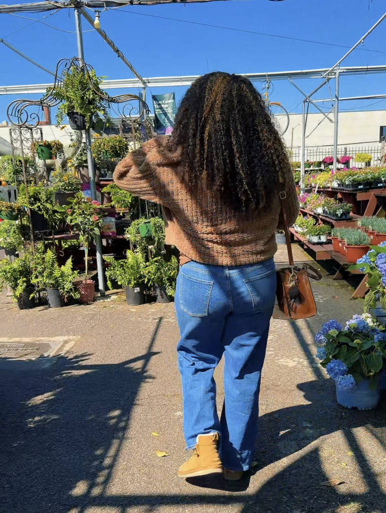 black woman walking into outdoor plant shop